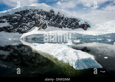 PORT DE NEKO, Antarctique—les montagnes glacées et rocheuses couvertes de glace et de neige à Neko Harbour sur la péninsule Antarctique se reflètent sur des eaux calmes miroiteuses. Banque D'Images