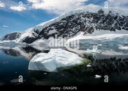 PORT DE NEKO, Antarctique—les montagnes glacées et rocheuses couvertes de glace et de neige à Neko Harbour sur la péninsule Antarctique se reflètent sur des eaux calmes miroiteuses. Banque D'Images