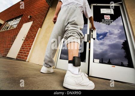 Aug 01, 2006 - Santa Ana, Californie, Etats-Unis - Le port d'un moniteur électronique à la cheville, un jeune délinquant entre dans un établissement de libération conditionnelle à Santa Ana, CA. Un moniteur de la cheville est un dispositif que les personnes à domicile sont souvent tenus de porter. À intervalles réguliers, la cheville monitor envoie une fréquence radio ou signal à un récepteur GPS. Si un contrevenant se promène à l'extérieur de sa admis Banque D'Images