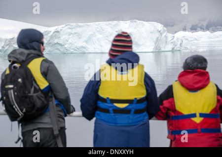 Antarctique passagers dans des gilets de sauvetage île de Cuverville // les passagers prêts dans leurs gilets de sauvetage admirent la vue sur le paysage en attendant de monter à bord des bateaux gonflables Zodiac pour se rendre à terre sur l'île de Cuverville sur le côté ouest de la péninsule Antarctique. Banque D'Images