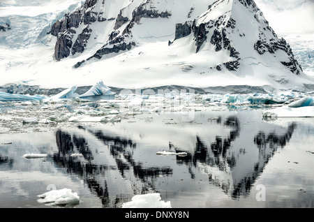 L'ANTARCTIQUE - une forte rocky mountain se reflète sur les eaux calmes comme vu de Cuverville Island sur le côté ouest de la péninsule antarctique. Banque D'Images