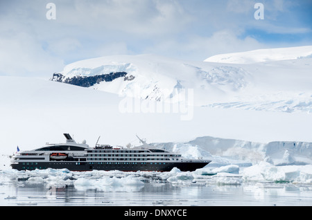 L'ANTARCTIQUE - un grand navire de croisière français de luxe, l'Austral, glisse par brash et passé de petits icebergs près de falaises de glace sur la péninsule antarctique. Banque D'Images