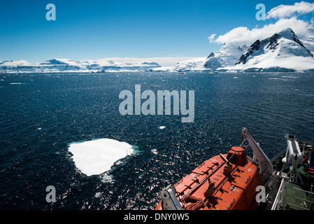 L'ANTARCTIQUE - un bateau de croisière passe par un canal long de petits icebergs. Au premier plan en bas à droite de l'image est l'un des canots de sauvetage du navire. Banque D'Images