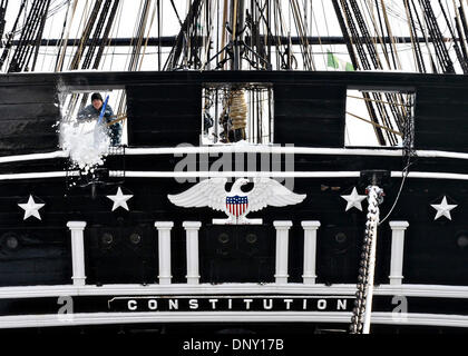 Un marin de l'US Navy neige pelles à travers l'un de l'arcasse ports d'armes à feu à bord du grand voilier le USS Constitution après Tempête Hercules qui a fait près de deux pieds de neige dans la région de Boston le 3 janvier 2014 à Charlestown, MA. Banque D'Images