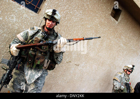 Jan 13, 2006 ; Abu Ghraib, Bagdad, l'Iraq ; Capitaine JIMMY KLEAGER, commandant de la Société A, 2e de la 22e Infanterie, 10e division de montagne, inspecte un fusil d'action que les sections locales remis lors d'une patrouille dans les régions agricoles au nord de l'Iraq, Abu Ghraib, 13 janvier 2006. Kleager vit près de Watertown (New York), l'agriculteur, qui s'appelait lui-même a dit, il a utilisé le fusil dans les années 30. M Banque D'Images