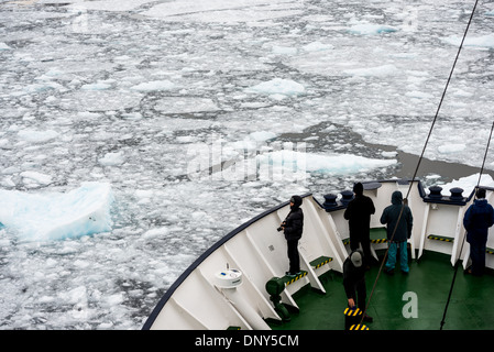 L'ANTARCTIQUE - les passagers debout sur la proue d'un navire de croisière antarctique renforcé comme il se déplace dans l'étroit canal Lemaire sur le côté ouest de la péninsule antarctique. Le Canal Lemaire est parfois appelée 'gap' Kodak dans un clin d'œil à son célèbre vue panoramique. Banque D'Images