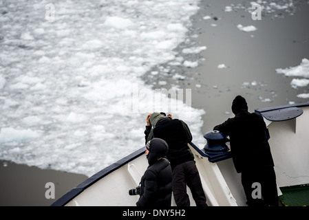 L'ANTARCTIQUE - les passagers debout sur la proue d'un navire de croisière antarctique renforcé comme il se déplace dans l'étroit canal Lemaire sur le côté ouest de la péninsule antarctique. Le Canal Lemaire est parfois appelée 'gap' Kodak dans un clin d'œil à son célèbre vue panoramique. Banque D'Images