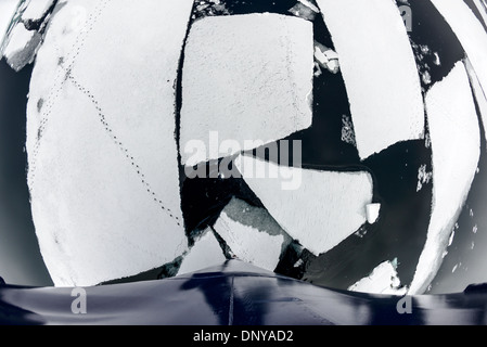 Sea Ice Penguin suit Petermann Island Antarctica // PETERMANN ISLAND, Antarctique — le Polar Pioneer, un navire renforcé par la glace, navigue à travers de minces couches de glace de mer, montrant sa capacité à opérer dans des conditions polaires difficiles. Des traces de pingouins sont visibles à travers la glace enneigée, ce qui indique la présence de ces oiseaux résilients dans la région. L'île Petermann est connue pour sa faune diversifiée, y compris plusieurs espèces de pingouins que l'on trouve couramment dans la région. Banque D'Images