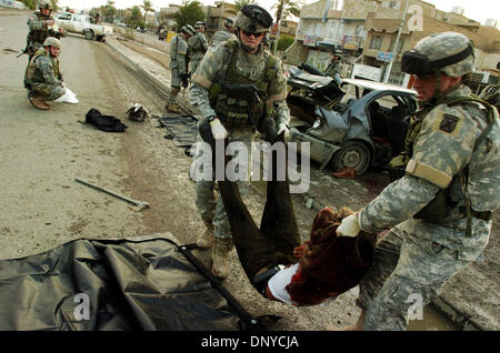 Jan 26, 2006 ; Abu Ghraib, Bagdad, Irak, soldats américains du 1er Escadron, 71e de cavalerie, d'effectuer un insurgé mort dans un sac mortuaire à Bagdad le 26 janvier 2006. L'insurgé a été tué 20 fois au cours d'un échange de tirs entre soldats américains et une voiture de quatre insurgés. Ministère irakien de la Défense cartes d'identification et des seringues préremplies ont été trouvés dans la voiture avec quatre AK-47 Banque D'Images