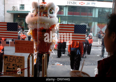 Jan 29, 2006 ; Manhattan, New York, USA ; NY POST. Une femme regarde un lion danse fait son chemin à travers les rues de Chinatown. Des pétards et de la danse du lion le coup d'envoi de la célébration du Nouvel An chinois dans le quartier chinois de New York. Selon le calendrier lunaire chinois c'est l'année du chien et la fête durera 15 jours se terminant à la pleine lune. Crédit obligatoire : Pho Banque D'Images