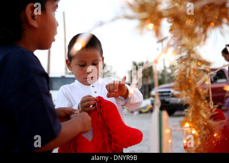 Feb 07, 2006 ; Pahokee, FL, USA ; Alex Rodriguez, 4, gauche, et Rafael Zavala, 4, accrocher des ornements sur un arbre de Noël à l'occasion d'une fête organisée par Larry Wright, de Pahokee, pour les résidents d'Usher's Trailer Park à Pahokee mardi. Les résidents du parc étaient sans électricité pendant 101 jours après l'ouragan Wilma a frappé la région. Trois églises de l'espace a permis de présenter, de l'alimentation et de vêtements f Banque D'Images