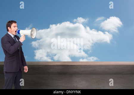 Image composite de standing businessman shouting through a megaphone Banque D'Images