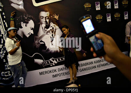 Mar 03 2006, Jakarta, Indonésie, et Java public Jazz pose à côté d'un néon d'un saxophone dans le Jakarta Java International Jazz Festival 2006. Autour de 1200 mis en scène des artistes et des milliers d'amateurs de jazz dont jouissent les performances dans les trois jours de festival de jazz. Sur la photo le 3 mars 2006. Crédit obligatoire : Photo par Toto Santiko Budi/JiwaFoto/ZUMA Press. ( ?) Copyright 2006 par JiwaFo Banque D'Images