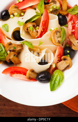 Pâtes Pappardelle aux champignons, les tomates, les olives et les feuilles de basilic Banque D'Images