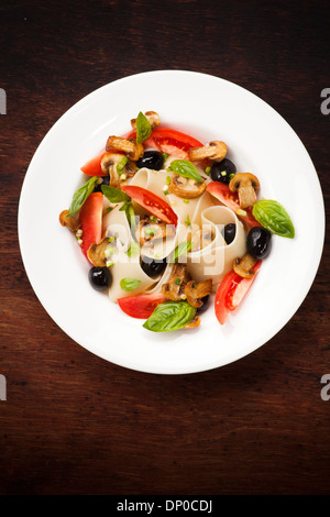 Pâtes Pappardelle aux champignons, les tomates, les olives et les feuilles de basilic Banque D'Images