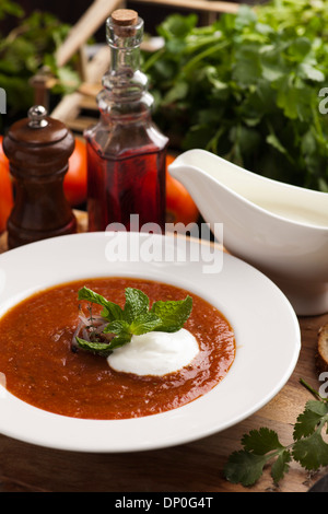 Bol de soupe aux tomates, délicieux grillé garni d'herbes et d'oignons grillés, servis avec creme Banque D'Images