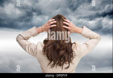 Composite image of Asian businessman with hands on head standing back to camera Banque D'Images