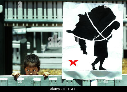 Mai 01, 2006 ; Ft. Pierce, FL, USA ; avec une affiche représentant un immigrant symbolique portant les Etats-Unis d'Amérique sur le dos, quatre ans, Alicia Solis de West Palm Beach regarde vers la direction des orateurs au cours d'un pique-nique et rallye parrainé par la Coalition d'Amérique latine de Ft. Pierce au Rotary Park lundi. Solis était pris tout en jouant sur l'équipement de jeu Banque D'Images