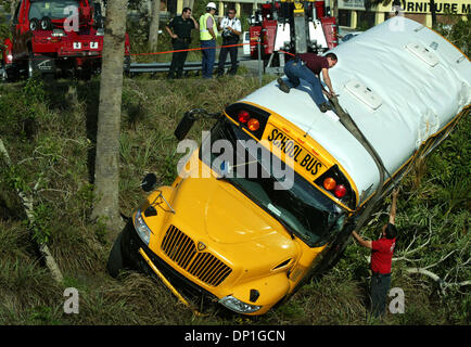 Mai 01, 2006 ; Ft. Pierce, FL, USA ; Tri-County employé automobile Anthony DiFrancesco (en plus d'autobus) travailler avec collègue Pete Bordonali, droit, œuvres d'attacher un harnais autour de la section médiane d'un autobus scolaire qui est parti l'Okeechobee Road I-95 sud rocade lundi matin. Les chaînes ont été fixé au faisceau et bus- deux dépanneuses lourdes ont été utilisées Banque D'Images