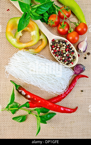 Fines nouilles de riz, tomates, poivrons différents, l'ail, le basilic sur un fond de tissu sac Banque D'Images