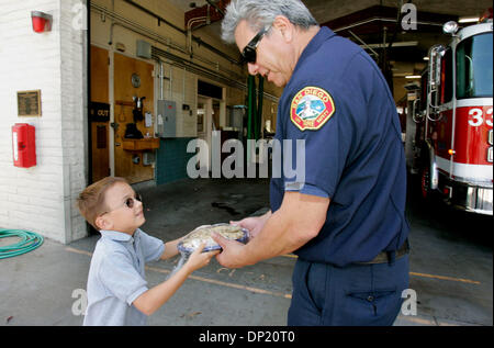 Le 12 mai 2006, à San Diego, CA, USA ; 8 ans WESLEY McCORD donne une assiette de cookies frais à San Diego de Pompiers Capitaine Tony Rivas ici à S.D.F.D.'s station 33 tout en visitant la station avec sa maman Patti. La station est dans le besoin de rénovation et de Wesley a été la première personne à donner de l'argent à la cause. Crédit obligatoire : Photo par Charlie Neuman/SDU-T/ZUMA Press. (©) Copyright 2 Banque D'Images