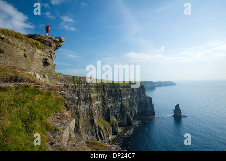 Walker sur le chemin des falaises de Moher, comté de Clare, Irlande. Banque D'Images