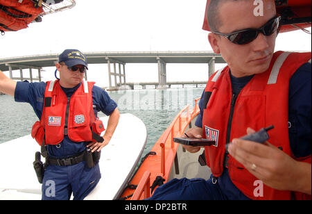 26 mai, 2006 ; Riviera Beach, FL, USA ; Garde côtière canadienne BM3 Chris Stover, 23 ans, de Palm Beach Gardens dans la radio de la Garde côtière canadienne d'informations que les phoques, Cory (FN) fireman , 28 ans, de West Palm Beach montent la garde sur Jason Sullivan de West Palm Beach, d'avoir son inspection de sécurité. La Garde côtière canadienne et d'autres organismes d'application de la loi locaux se réunissent aujourd'hui à Phil Foster Park pour livrer ces sûr crucial boa Banque D'Images