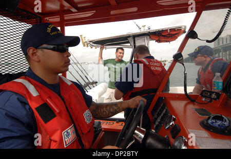 26 mai, 2006 ; Riviera Beach, FL, USA ; Jason Sullivan de West Palm Beach, (chemise verte), a été intercepté par la Garde côtière BM3 Chris Stover, 23 ans, de Palm Beach Gardens (FN) Cory pompier Seale, 28 ans, de West Palm Beach, à l'extrême droite, tandis que l'écoute sur le BM2 Chris Cowart, 23, un résident de West Palm Beach conserve deux bateaux pendant que Jason ralenti son bateau de pêche inspecté pour points de sécurité Banque D'Images