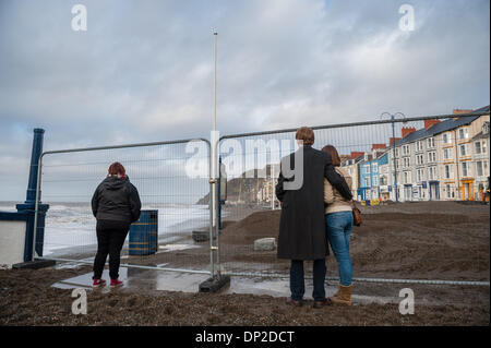 Aberystwyth, Pays de Galles, Royaume-Uni. 7 janvier 2014. Comme l'orage s'apaise, le plein impact de plusieurs jours d'immenses marées et vagues gigantesques devient évident à voir sur la promenade d'Aberystwyth, Pays de Galles, Royaume-Uni. L'autorité locale a coupé la promenade pour permettre à l'opération de nettoyage de procéder en toute sécurité, avec les badauds conservés derrière une clôture sécurisée Crédit photo : Keith morris/Alamy Live News Banque D'Images