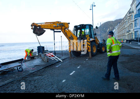 Aberystwyth, UK. 7 janvier 2014. Travaux de réparation va de l'avant comme la station balnéaire victorienne de Aberystwyth entre dans le cinquième jour d'être battu par d'énormes vagues et des vents violents résultant d'une onde de tempête associée à un système de basse pression situé au nord-ouest de l'Écosse. Credit : Graham M. Lawrence/Alamy Live News. Banque D'Images