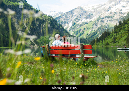 Couple assis sur un banc près du lac, Woman Jogging in forest Banque D'Images