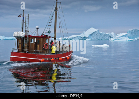 Les touristes en bateau de pêche entre les icebergs dans la baie de Disko, Ilulissat, Groenland Ouest Banque D'Images