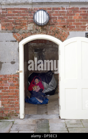 Personnes âgées femme sans-abri avec son chien prend un abri contre les tempêtes d'hiver sur la côte sud de l'Angleterre, Royaume-Uni Banque D'Images