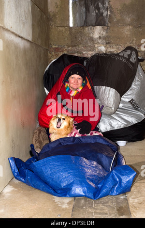 Personnes âgées femme sans-abri avec son chien prend un abri contre les tempêtes d'hiver sur la côte sud de l'Angleterre, Royaume-Uni Banque D'Images