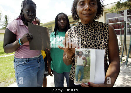 Jun 30, 2006 ; Ft. Pierce, FL, USA ; Debbie Ferguson soutient une photo de son défunt frère, Craig Ferguson le jeudi devant son domicile sur N. 51e St. à Fort Pierce. Craig's Allisia Bain, et la fille de Craig Ferguson, Craigrita se tenir derrière. Craig s'est noyé dans le canal près de chez lui tôt jeudi matin après avoir tenté de faire allusion, la police. Crédit obligatoire : Photo par Amanda Voisard Banque D'Images