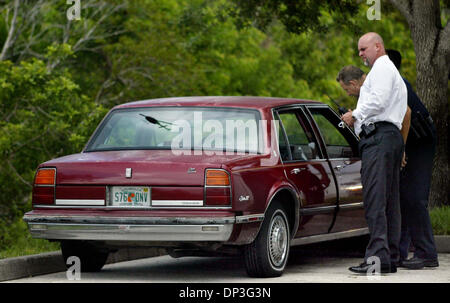 Juillet 05, 2006 ; Port Saint Lucie, FL, USA ; Sgt. Kevan Carmichael et Port Saint Lucie bureau recherchez la voiture d'un suspect impliqué dans un sac à main armée derrière l'East Port Plaza à l'angle de Walton et autoroute fédérale le mercredi après-midi. Un hélicoptère de police reflète dans la fenêtre arrière sida dans la recherche. L'un des deux suspects a été arrêté. Crédit obligatoire : Photo par Amanda Voi Banque D'Images