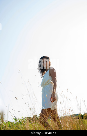 Portrait of little Girl standing in field sur journée d'été, looking at camera, Allemagne Banque D'Images