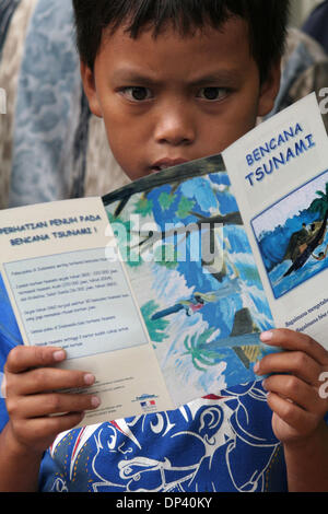 Jul 20, 2006 ; Ciamis, Java ouest, Indonésie ; l'enfant dans le centre de réfugiés se lit une brochure au sujet des tsunamis. Les brochures ont été offerts par l'Université de Gadjah Mada tremblement de terre et Tsunami Research Centre de Yogyakarta. Les villageois qui ont survécu au tsunami inquiète encore sur les possibilités d'un autre tremblement de terre et le tsunami. Un tsunami a frappé la côte de l'île indonésienne de Java kil Banque D'Images