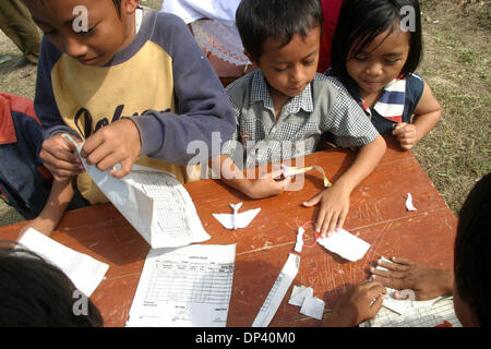 Jul 20, 2006 ; Ciamis, Java ouest, Indonésie ; les enfants au centre des réfugiés dans les collines de Pangandaran passent leur temps à faire des avions en papier. Les villageois qui ont survécu au tsunami inquiète encore sur les possibilités d'un autre tremblement de terre et le tsunami. Un tsunami a frappé la côte de l'île indonésienne de Java, tuant plus de 550 personnes, laissant plus de 600 blessés. Plus de 38 000 autres Banque D'Images