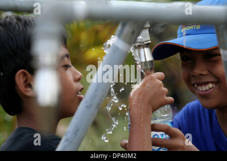 Jul 20, 2006 ; Ciamis, Java ouest, Indonésie ; les enfants séjournant à l'centre de réfugiés dans les collines de Pangandaran, Java ouest heureusement remplir leurs bouteilles avec de l'eau propre. Les villageois qui ont survécu au tsunami inquiète encore sur les possibilités d'un autre tremblement de terre et le tsunami. Un tsunami a frappé la côte de l'île indonésienne de Java, tuant plus de 550 personnes, laissant l'ove Banque D'Images