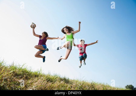 Jeunes filles sautant en l'air plus de champ, Allemagne Banque D'Images