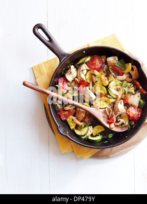 Vue de dessus le poulet et champignons Ratatouille à la poêle en fonte avec une cuillère de bois, Studio Shot Banque D'Images