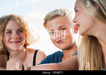 Close-up portrait of teenage girls et boy sitting outdoors, Allemagne Banque D'Images