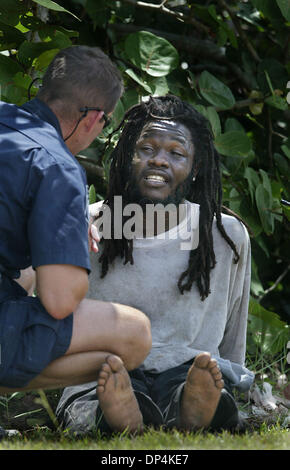 Aug 16, 2006 ; Jupiter Island, Floride, USA ; UN U.S. Customs and Border Protection questions agent un Haïtien ils ont arrêté après une équipe d'arpentage l'a trouvé caché dans les buissons le long de la voie d'eau. inracoastal U.S. Customs and Border Protection a trouvé deux Haïtiens débarquer sur les rives près de Jupiter Island à environ 2:50 h le mercredi. Ils ont dit qu'ils ont débarqué avec 12 personnes, la Côte Banque D'Images