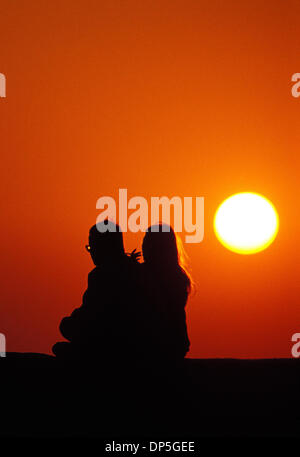 15 Sep 2006, Taipei, Taïwan ; couple assis sur un talus au bord de l'océan, regarder le coucher de soleil. Fisherman's Wharf, près de Tamsui, au nord de Taiwan. Crédit obligatoire : Photo par Chris Stowers/JiwaFoto/ZUMA Press. (©) Copyright 2006 par JiwaFoto Banque D'Images