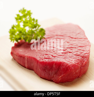 Steak cru sur une planche en bois avec garniture rôti prêt à vous Banque D'Images