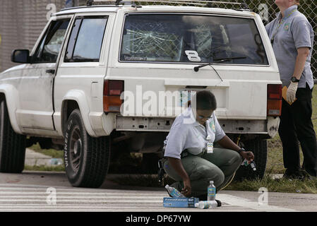 Oct 08, 2006 ; West Palm Beach, FL, USA ; UN PBSO scène de crime atteint pour une paire de gants qu'elle rassemble des evidentce à partir d'un double-meurtre a eu lieu à environ 2 h 40 Dimanche matin, à l'intersection de Hiawatha et Osceola dans West Palm Beach. Ici, un Palm Beach County Sheriff's préposé inspecte le véhicule où les victimes ont été abattues. Crédit obligatoire : Photo par Libby V Banque D'Images