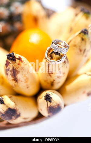 Anneaux d'or de mariage sur la banane fruit, mariage dans tropiques Banque D'Images