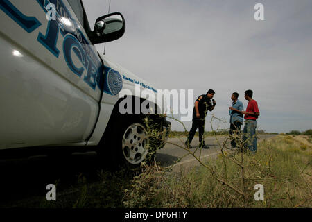 Oct 05, 2006 ; nation Tohono O'odham, USA ; Sgt. ELTON BEGAY, 33, à gauche, des entretiens avec les deux migrants il s'est arrêté alors qu'ils marchaient vers le nord sur une route à partir de la frontière, par l'intermédiaire de la nation Tohono O'odham. Les hommes, RODRIGO, gauche, et Ricardo SALAZAR avait été marche à travers le désert sans eau ni nourriture. Ils ont dit qu'ils avaient essayé de flag down Border Patrol à deux reprises, en vain. Tohono O'od Banque D'Images