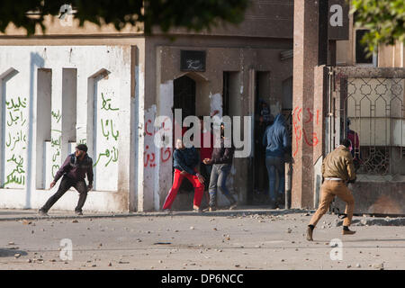 Le Caire, Égypte. 8 janvier, 2014. Les étudiants qui protestaient jeter des pierres à la police en face de l'Université Al-Azhar au Caire, en Egypte, le 8 janvier 2014. La Cour pénale du Caire a été suspendue le mercredi le procès de l'ancien président déchu Mohamed Morsi sur incitation meurtre de manifestants pour le 1er février à cause des intempéries qui ont empêché son transport à la cour, la télévision d'Etat a signalé. Credit : Cui Xinyu/Xinhua/Alamy Live News Banque D'Images